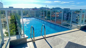 Passos da praia c/ piscina apto iluminado e novo